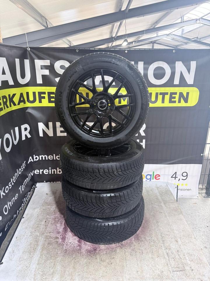 Schwarze Alufelgen mit Winterreifen als Komplettradsatz im Reifen- und Felgenlager von Your Next Car